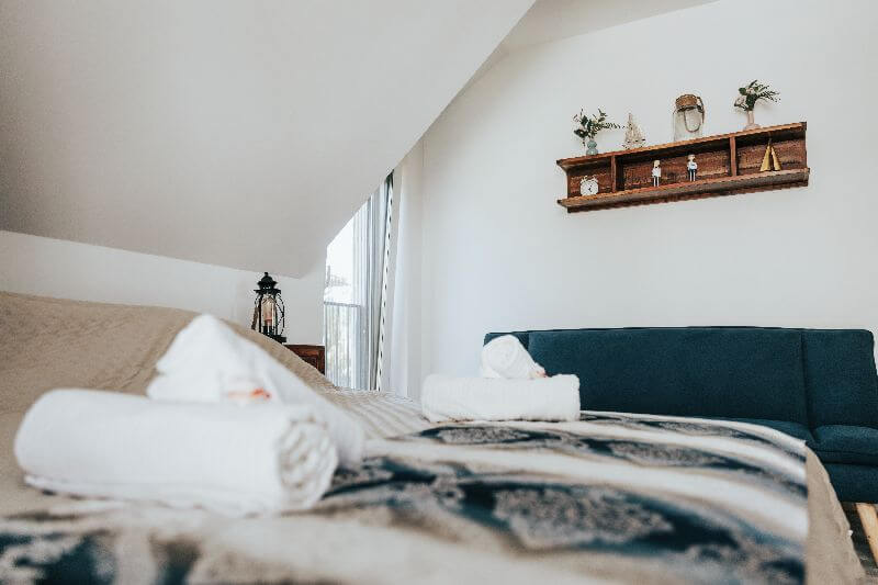 Tetőtéri hálószoba franciaággyal és tiszta törölközőkkel a zamárdi apartmanban